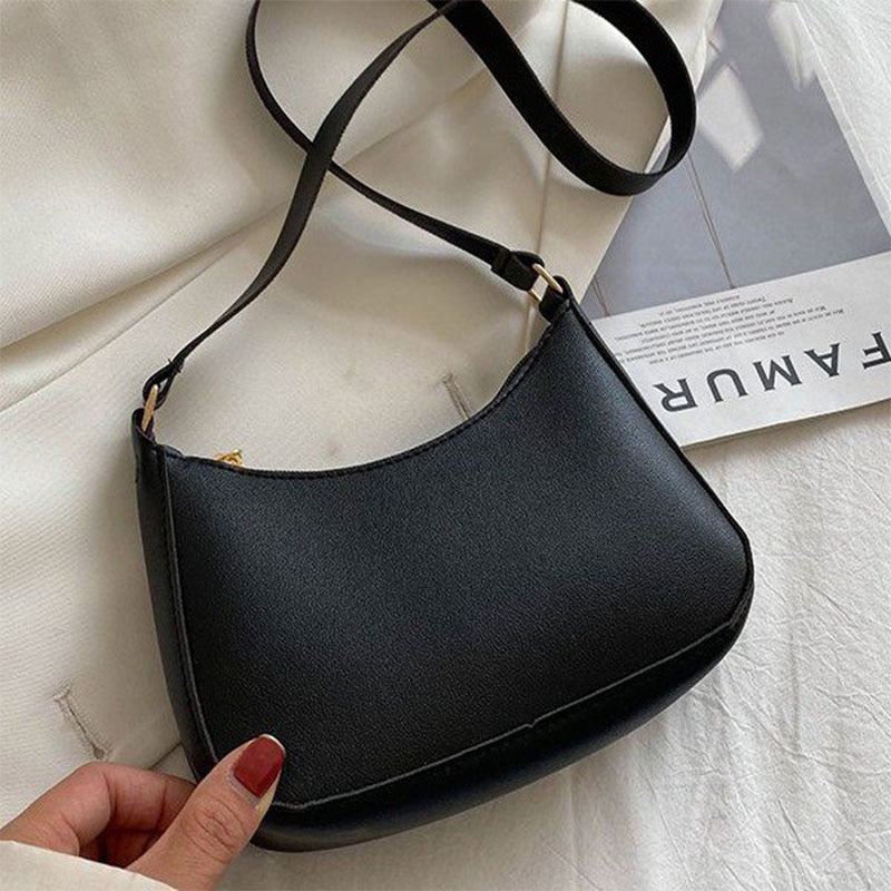 Borsa a tracolla nera in pelle sintetica su sfondo bianco, design elegante e minimalista, perfetta per moda femminile e accessori di tendenza.