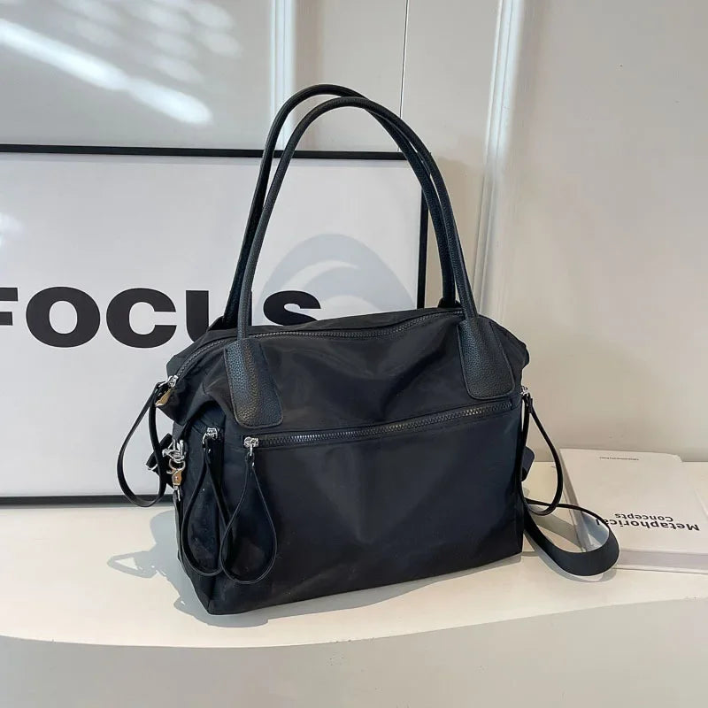 Borsa a mano nera elegante in pelle sintetica, design moderno con doppio manico e tracolla regolabile, ideale per moda donna e uso quotidiano.
