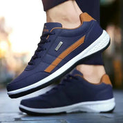 Scarpe da ginnastica blu e marroni da uomo, suola bianca, design moderno, ideali per sport e tempo libero. Comfort e stile per ogni occasione.