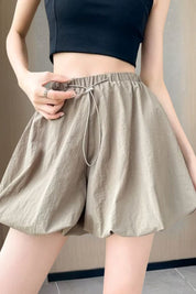 Shorts donna beige a vita alta, tessuto leggero, con elastico e laccio in vita. Abbigliamento estivo casual, moda femminile trendy.