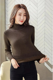 Donna con maglione a collo alto marrone, posa elegante. Moda autunno inverno, abbigliamento casual femminile, stile moderno e confortevole.