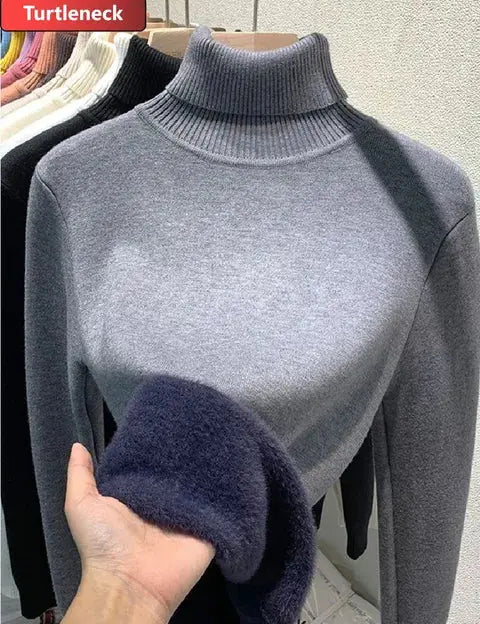 Maglione dolcevita grigio in lana, manica lunga, esposto su manichino. Tessuto morbido, ideale per moda autunno-inverno.