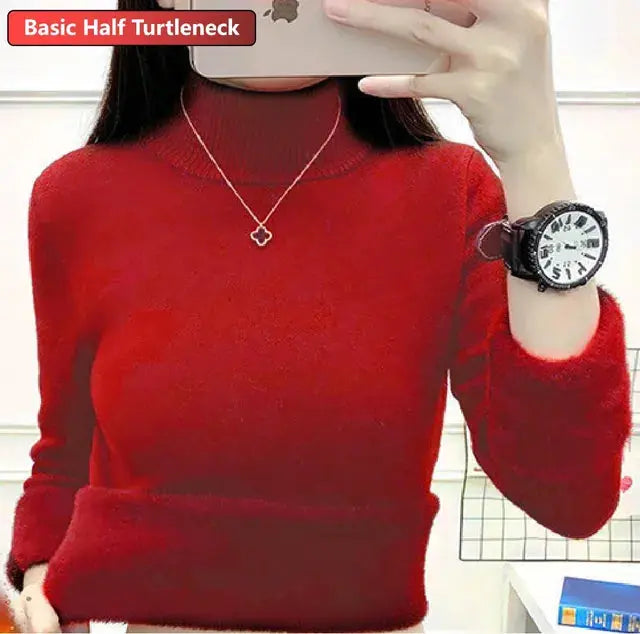 Maglione rosso a collo alto, maniche lunghe, indossato da una persona. Include orologio nero e collana con ciondolo a forma di fiore.