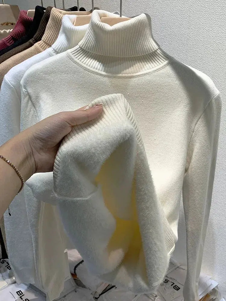 Maglione dolcevita bianco in lana, morbido e caldo, esposto su appendiabiti. Moda invernale, abbigliamento donna, tessuto di alta qualità.