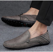 Scarpe mocassino uomo in pelle grigia, suola antiscivolo, design elegante e casual, ideali per abbigliamento formale e quotidiano.