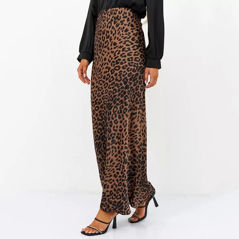 Gonna lunga a vita alta con stampa leopardata, indossata con sandali neri e camicetta nera. Moda donna, abbigliamento elegante, stile animalier.