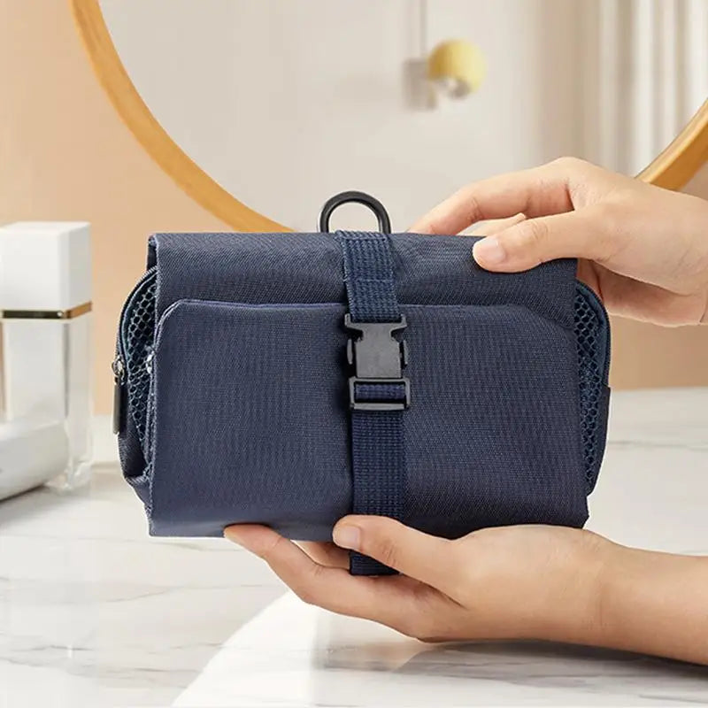 Borsa da viaggio blu compatta con chiusura a fibbia, ideale per organizzare accessori da bagno. Design elegante e pratico per viaggiatori.