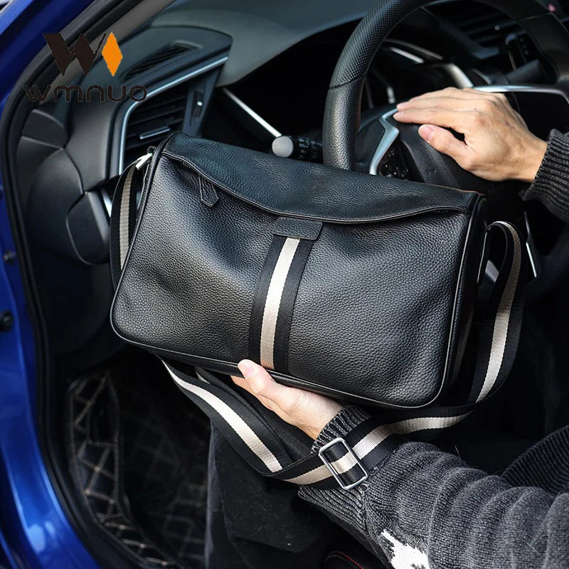 Borsa a tracolla in pelle nera con strisce bianche, tenuta in auto. Design elegante, ideale per uomo, accessorio moda, alta qualità.