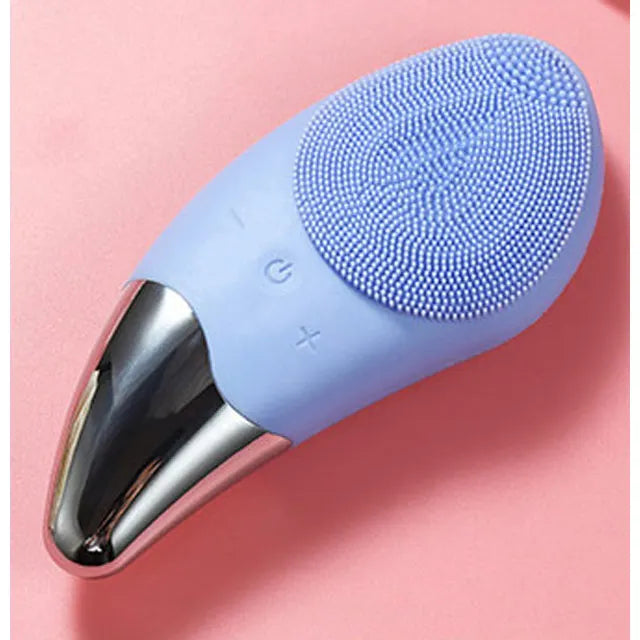 Spazzola viso elettrica in silicone blu su sfondo rosa, con pulsanti di controllo e base in metallo. Dispositivo per pulizia e cura della pelle.