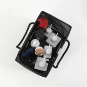 Cestino organizer nero con manici, contenente flaconi cosmetici e accessori da bagno. Ideale per organizzare prodotti di bellezza e cura personale.