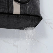 Borsa impermeabile nera in tessuto resistente, angolo inferiore con acqua che scorre, ideale per viaggi e uso quotidiano.