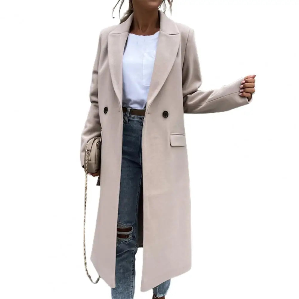 Cappotto lungo beige da donna, elegante e moderno, con bottoni doppi, abbinato a jeans strappati e borsa a tracolla. Moda autunnale casual.