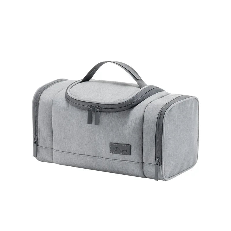 Borsa da viaggio grigia con manico, design compatto e zip, ideale per organizzare articoli da toeletta. Perfetta per viaggi e spostamenti.