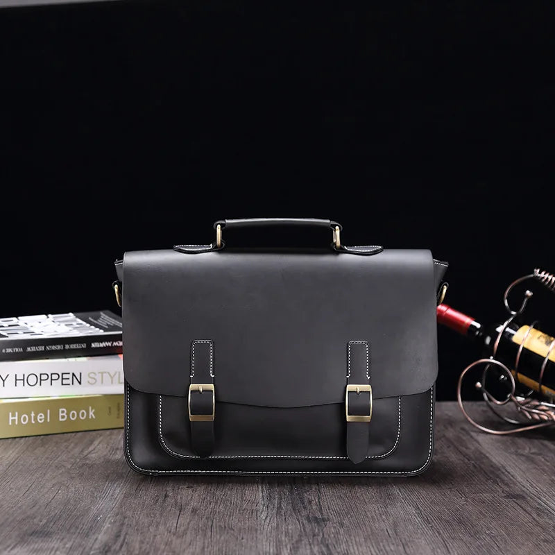 Elegante borsa ventiquattrore in pelle nera con fibbie dorate, ideale per lavoro e ufficio. Design classico su sfondo scuro, perfetta per professionisti.