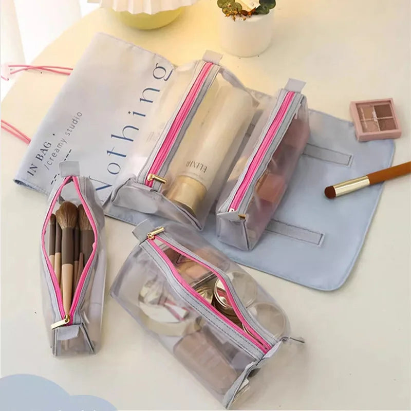 Set di quattro astucci trasparenti con cerniera rosa, contenenti pennelli e cosmetici, su sfondo chiaro. Ideale per organizzare il trucco.