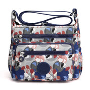 Borsa a tracolla floreale multicolore con tasche multiple e cerniere, design moderno e pratico, ideale per uso quotidiano e viaggi.