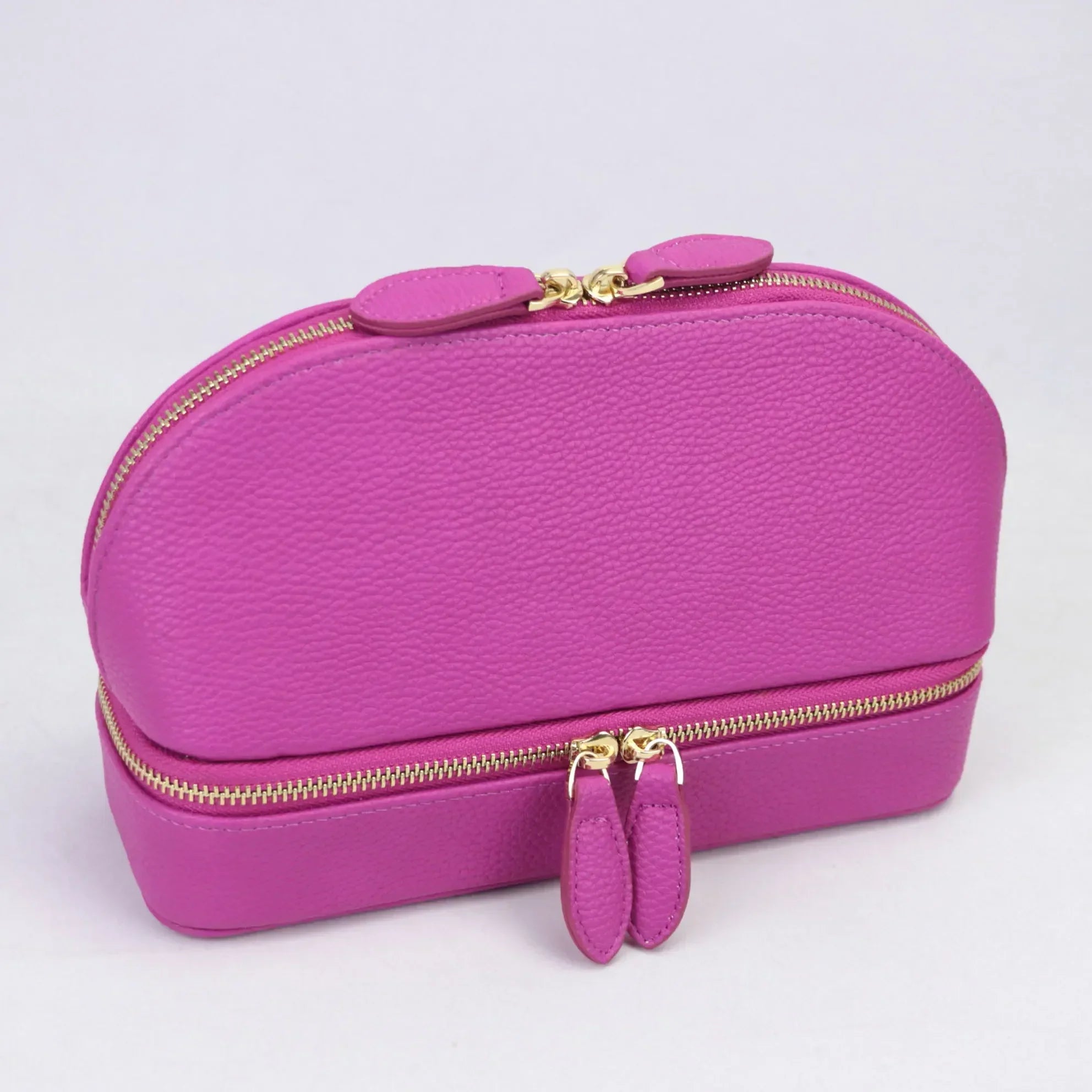 Borsa cosmetica viola in pelle con doppia cerniera dorata, design elegante e compatto, ideale per organizzare trucchi e accessori da viaggio.