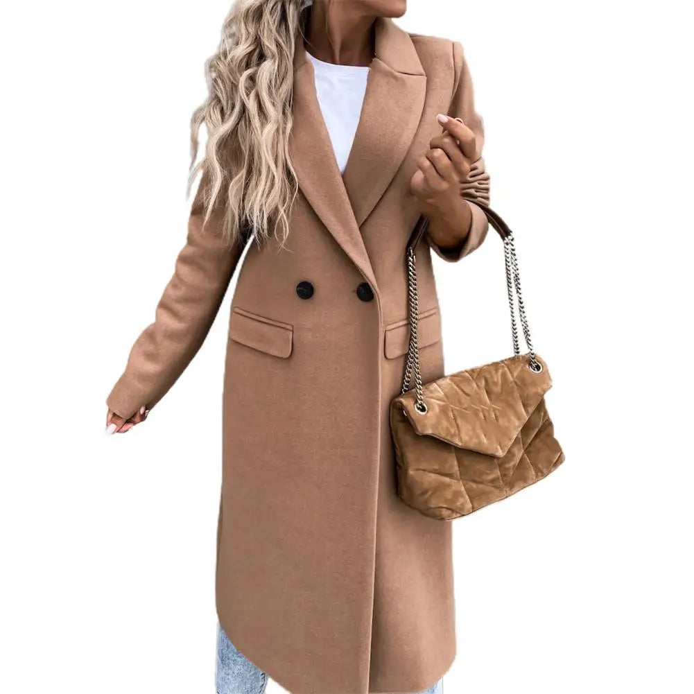 Cappotto lungo donna color cammello, elegante e moderno, con bottoni neri. Abbinato a borsa trapuntata marrone chiaro. Moda autunnale chic.