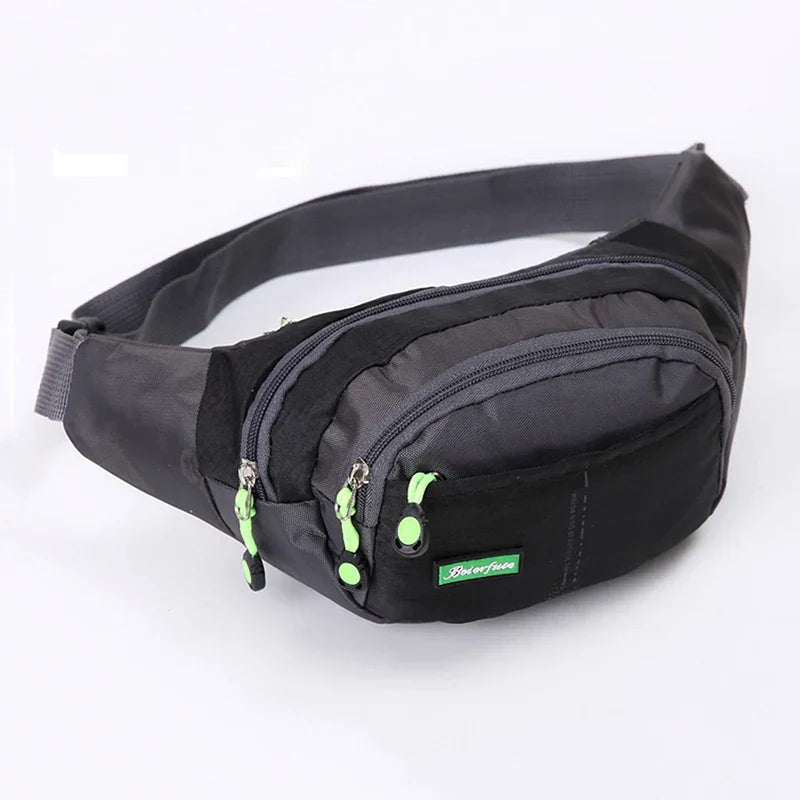 Marsupio sportivo nero e grigio con cerniere verdi, ideale per attività all'aperto. Design compatto e resistente, perfetto per escursioni e viaggi.