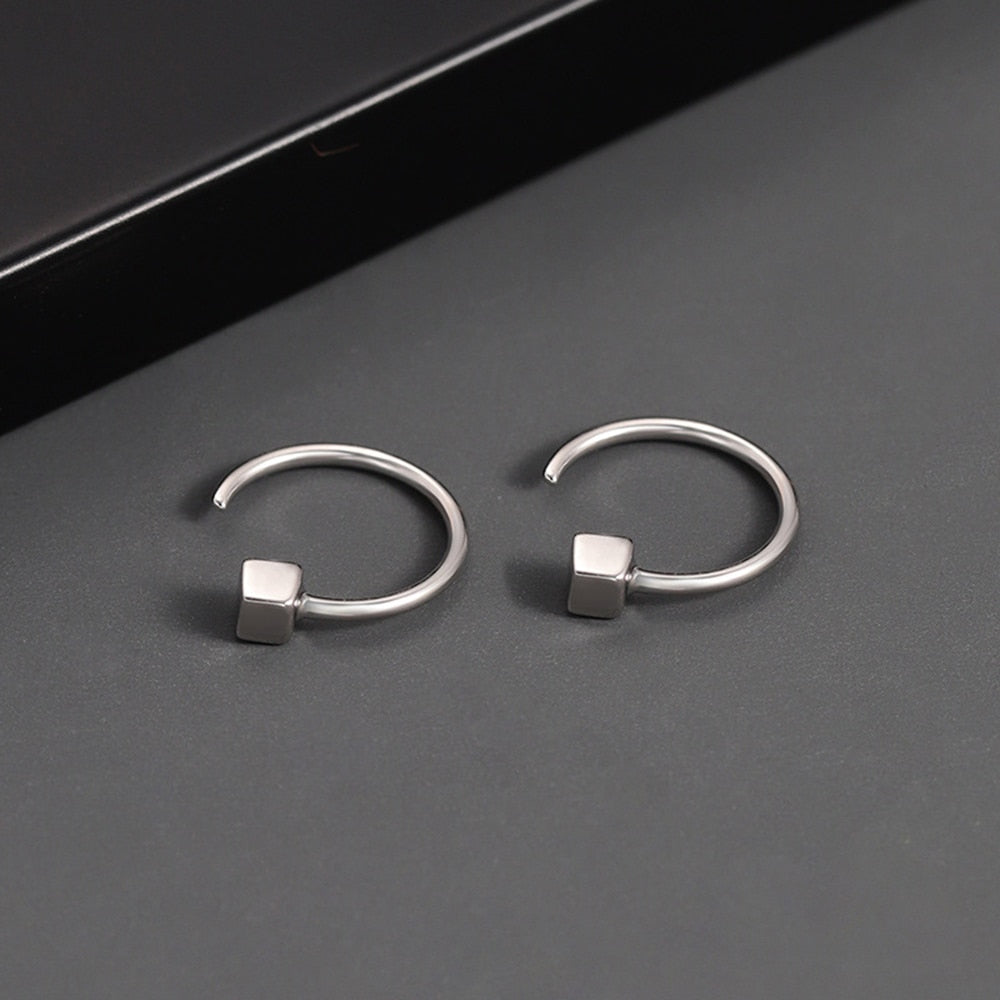 Orecchini a cerchio in argento con design minimalista e cubo geometrico, eleganti e moderni, ideali per moda donna e accessori gioielli.