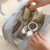 Borsa cosmetica aperta con trucchi e skincare, contenente rossetti, creme e flaconi. Organizzazione prodotti bellezza, accessori viaggio.
