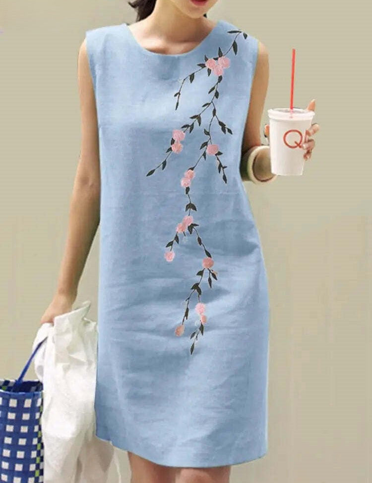 Abito estivo donna azzurro senza maniche con stampa floreale rosa, stile casual. Perfetto per giornate calde, moda femminile elegante.