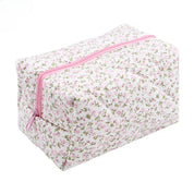 Astuccio cosmetico floreale con cerniera rosa, design trapuntato, ideale per trucco e accessori da viaggio. Stile elegante e pratico.