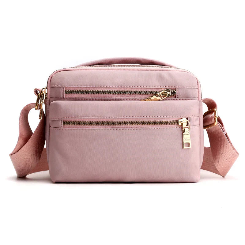 Borsa a tracolla rosa in nylon con cerniere dorate, tasche multiple, design compatto e moderno, ideale per donna, moda casual.