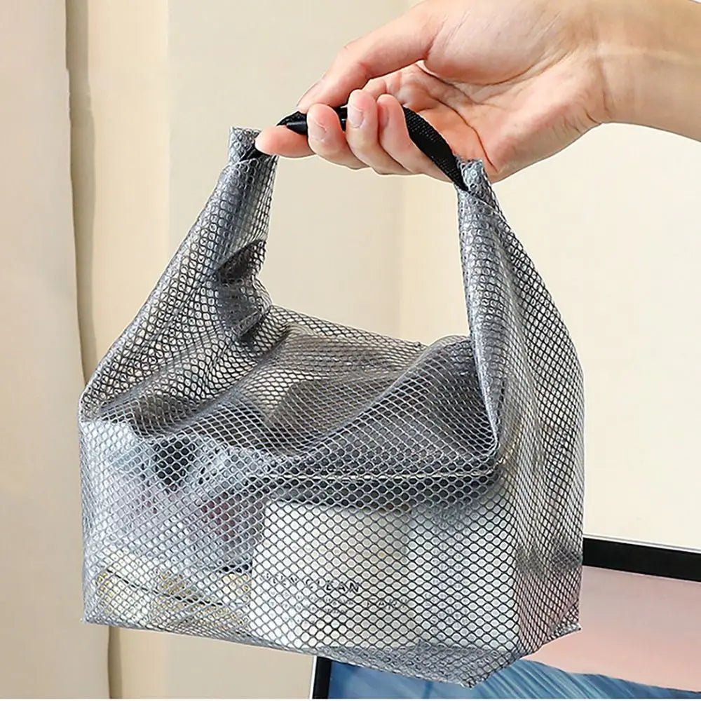 Borsa organizer in rete grigia trasparente, portatile, con manico, contenente prodotti cosmetici. Ideale per viaggi e organizzazione bagno.