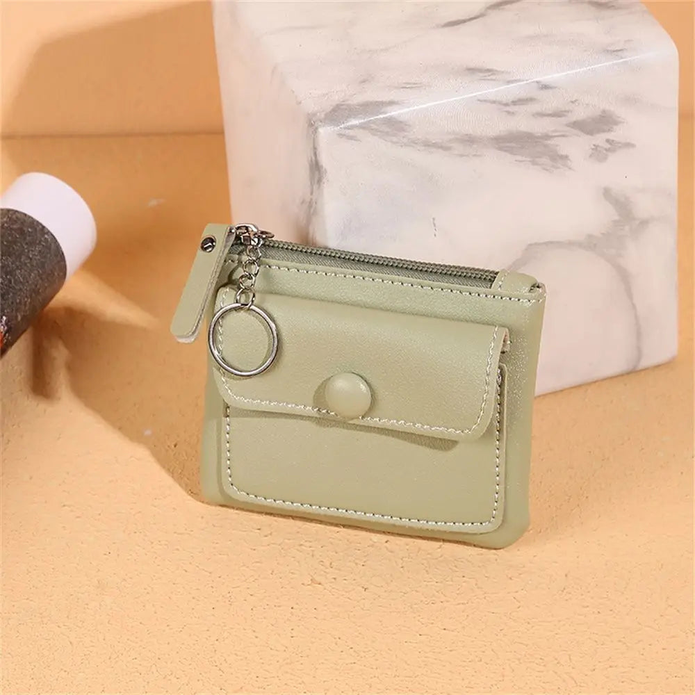 Portafoglio donna in pelle verde chiaro con cerniera e tasca frontale, anello portachiavi, design elegante, accessorio moda femminile.
