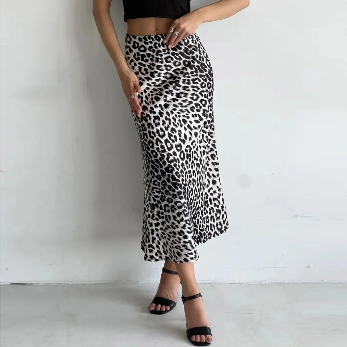 Gonna lunga leopardata bianca e nera, indossata con top nero e sandali neri. Moda donna, abbigliamento elegante, stile animalier.
