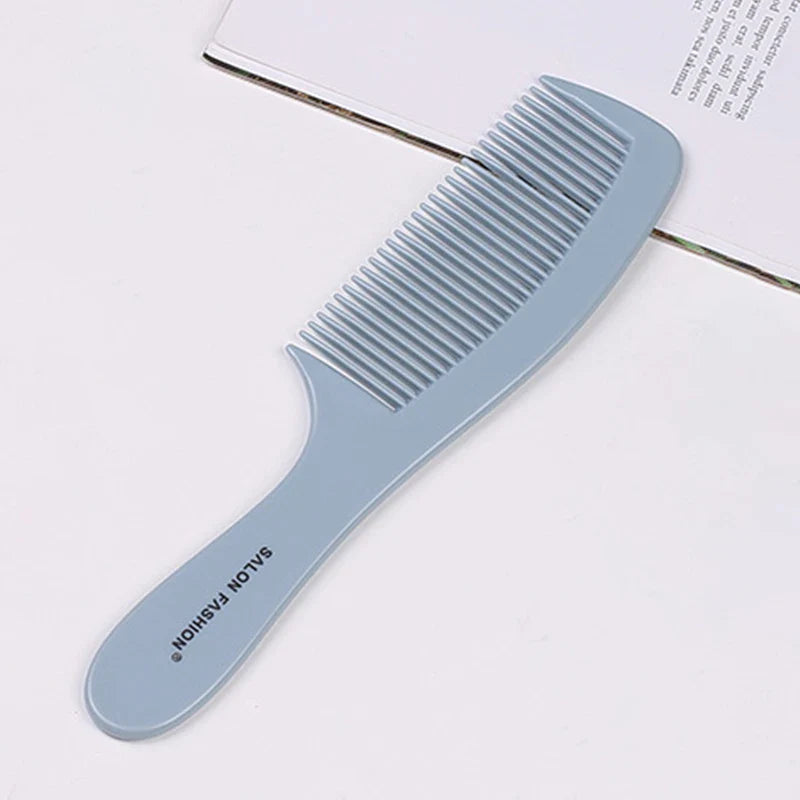 Pettine grigio in plastica con manico ergonomico su sfondo bianco, ideale per capelli ricci e crespi. Accessorio per cura dei capelli.
