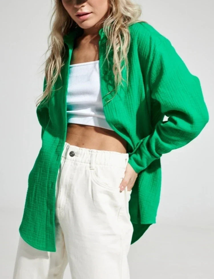 Camicia verde donna, tessuto leggero, abbinata a top bianco e pantaloni bianchi. Moda casual estiva, stile trendy e fresco.