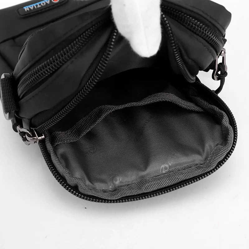 Marsupio nero in nylon con doppia cerniera aperta, tasca interna spaziosa, design resistente all'acqua, ideale per viaggi e attività all'aperto.