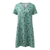 Abito estivo verde con motivo a foglie, maniche corte e scollo a V. Vestito casual donna, ideale per la moda estiva e look quotidiani.
