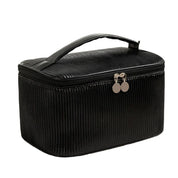 Elegante borsa cosmetica nera con manico, design a righe, chiusura a zip, ideale per organizzare trucchi e accessori da viaggio.