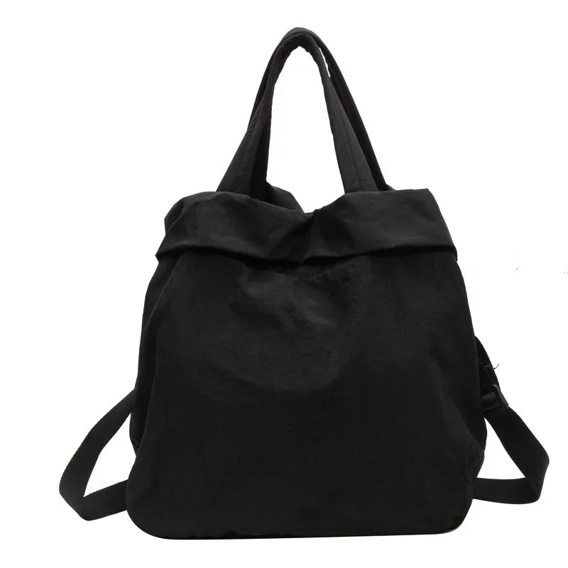 Zaino nero in tessuto, design minimalista, con manici e spallacci regolabili. Ideale per scuola, lavoro, viaggio. Accessorio moda unisex.