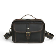 Borsa a tracolla in pelle marrone scuro con fibbia, tasca frontale e cuciture a contrasto. Elegante e resistente, ideale per uomo e donna.