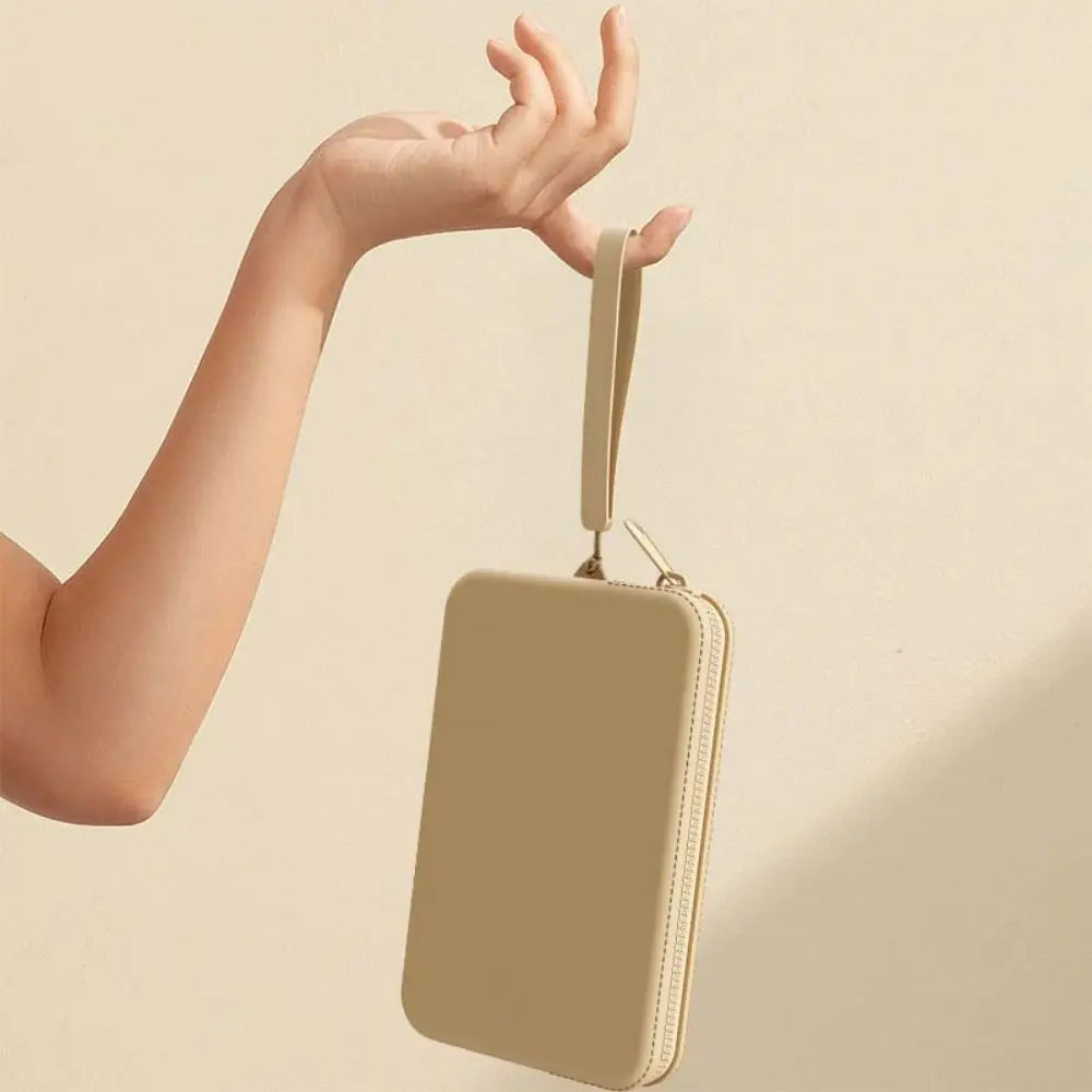Mano che tiene una pochette beige elegante, design minimalista, chiusura a zip, ideale per moda donna, accessorio versatile e chic.