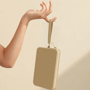 Mano che tiene una pochette beige elegante, design minimalista, chiusura a zip, ideale per moda donna, accessorio versatile e chic.