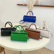 Cinque borse a mano colorate su tavolo rotondo, design moderno, pelle sintetica, chiusura a scatto, perfette per moda donna.