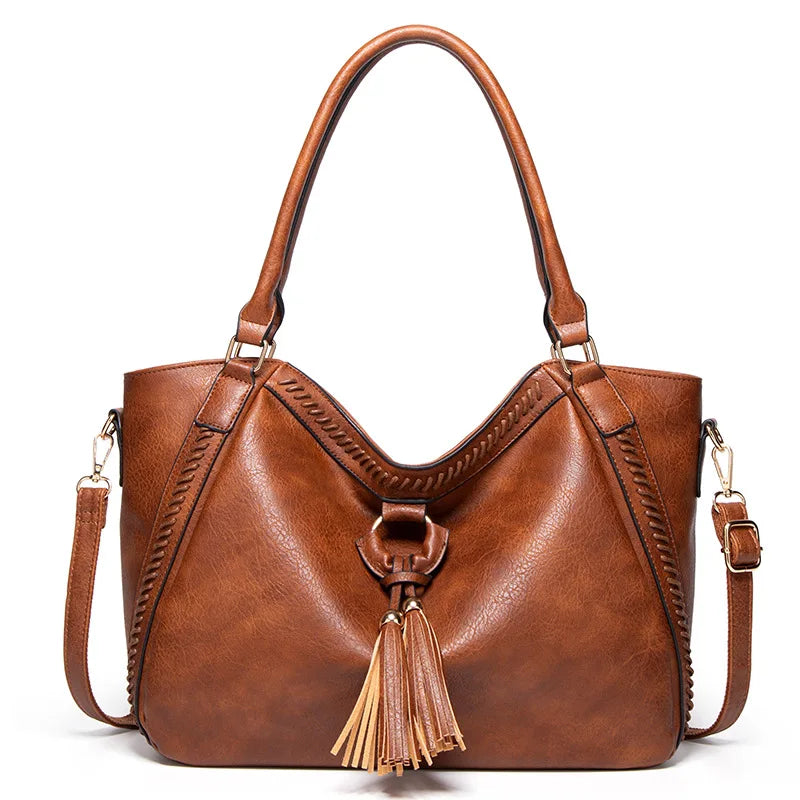 Borsa a spalla in pelle marrone con nappine, design elegante, manici doppi e tracolla regolabile. Accessorio moda donna, stile casual chic.
