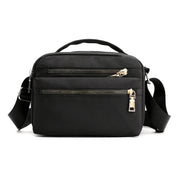 Borsa a tracolla nera in nylon con doppia cerniera, manico superiore e tracolla regolabile. Design elegante e pratico per uso quotidiano.
