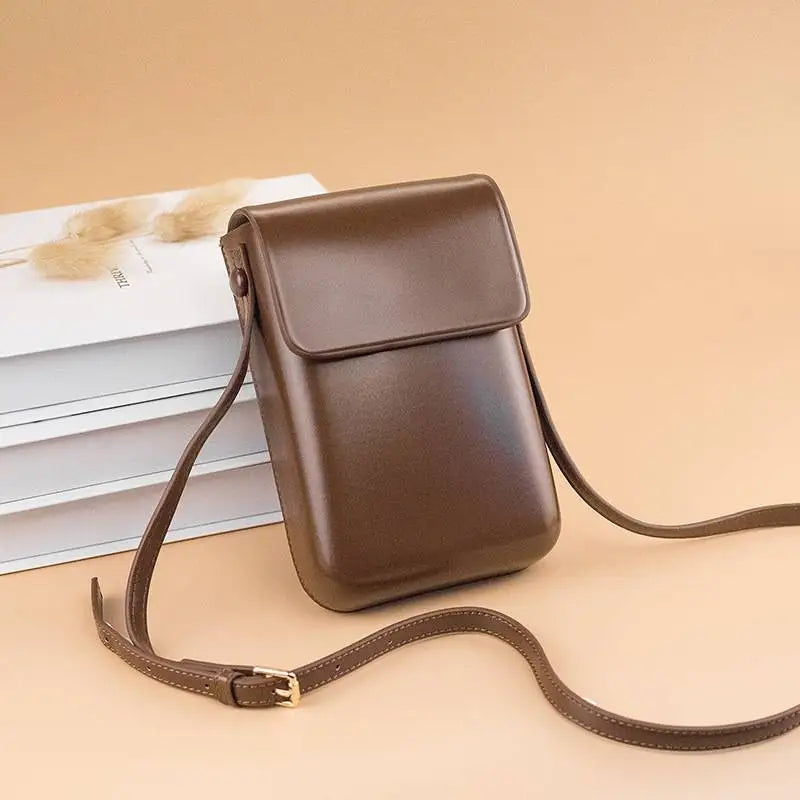 Borsa a tracolla in pelle marrone su sfondo beige, design elegante e minimalista, ideale per moda donna, accessori di tendenza, shopping online.