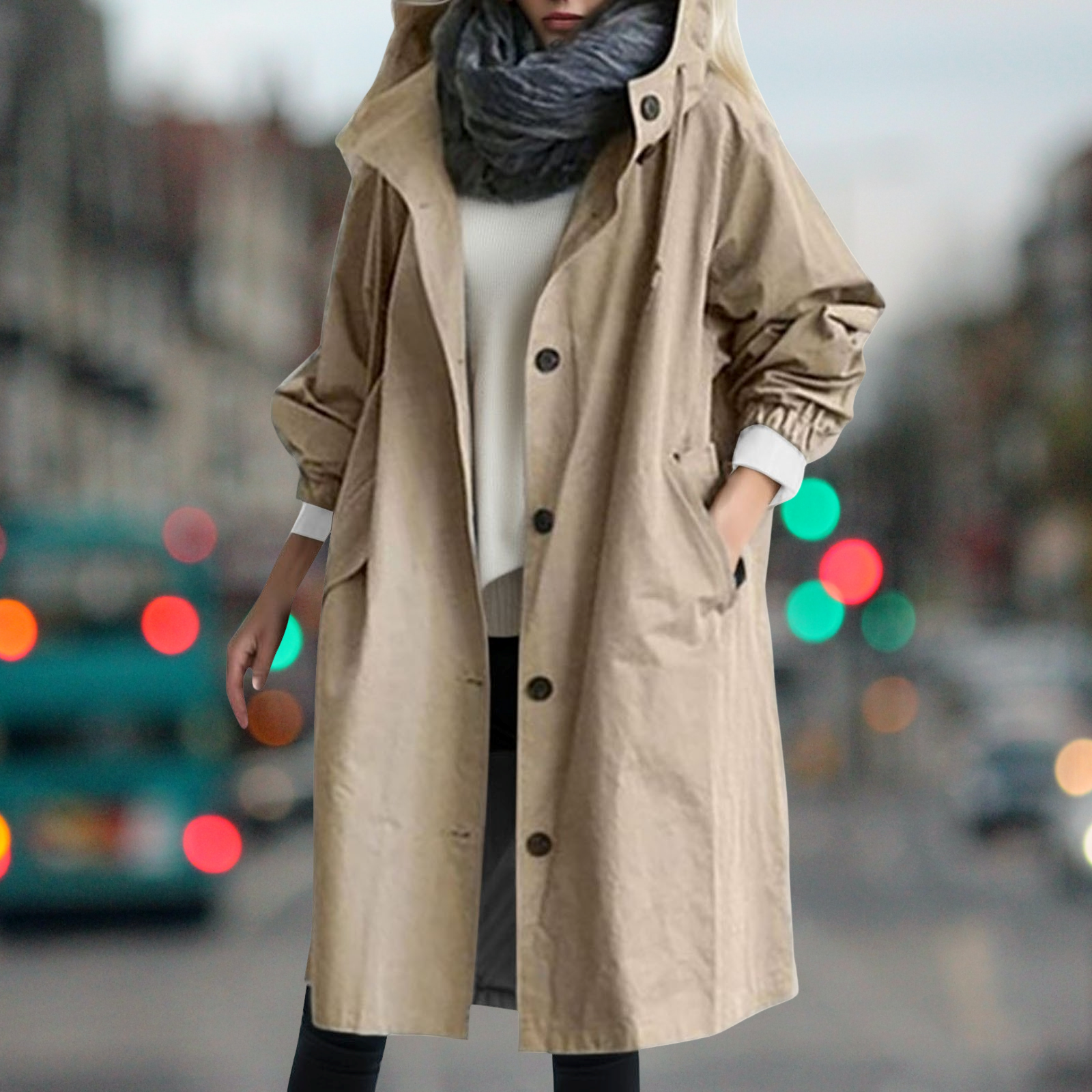 Cappotto beige con cappuccio, bottoni grandi e tasche, indossato su maglione bianco e sciarpa grigia. Moda autunnale donna, stile urbano.