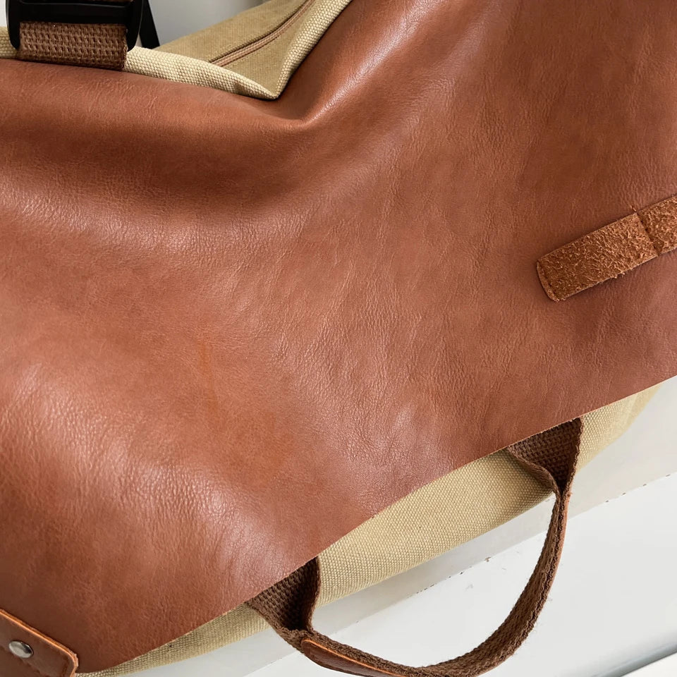 Borsa da viaggio in pelle marrone e tessuto beige, manici robusti, design elegante, ideale per viaggi e uso quotidiano. Accessorio moda versatile.