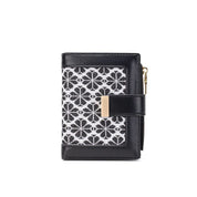 Portafoglio donna in pelle nera con motivo geometrico bianco e nero, chiusura a zip dorata, design elegante e compatto, accessorio moda.
