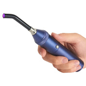 Mano che tiene una lampada polimerizzante dentale LED blu, portatile e ergonomica, per indurimento rapido di materiali odontoiatrici.