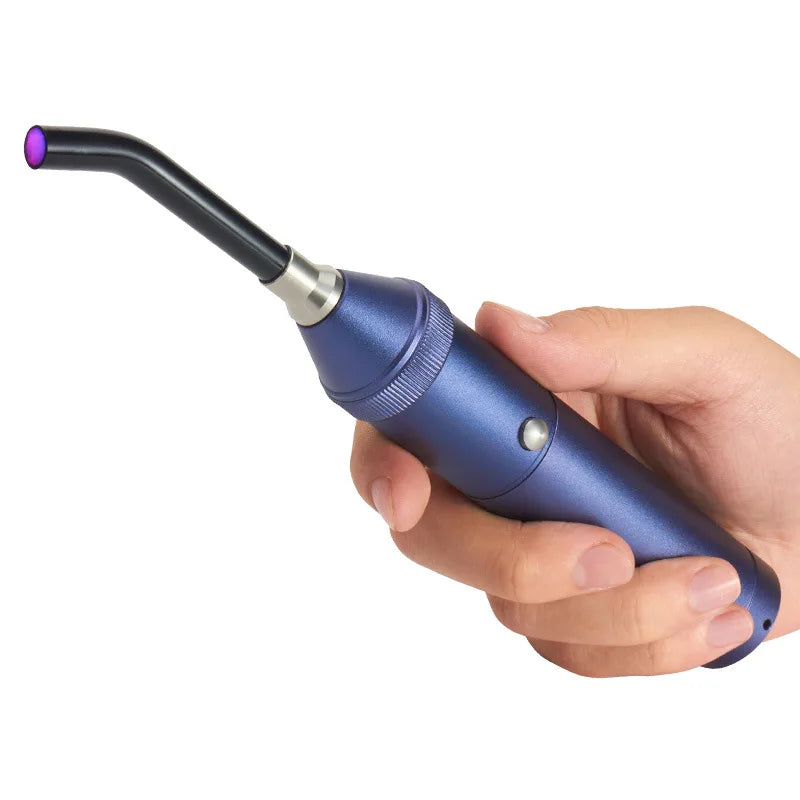 Mano che tiene una lampada polimerizzante dentale LED blu, portatile e ergonomica, per indurimento rapido di materiali odontoiatrici.