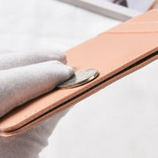 Portafoglio sottile in pelle beige, mostrato con moneta per evidenziare lo spessore. Design elegante, accessorio moda uomo e donna.